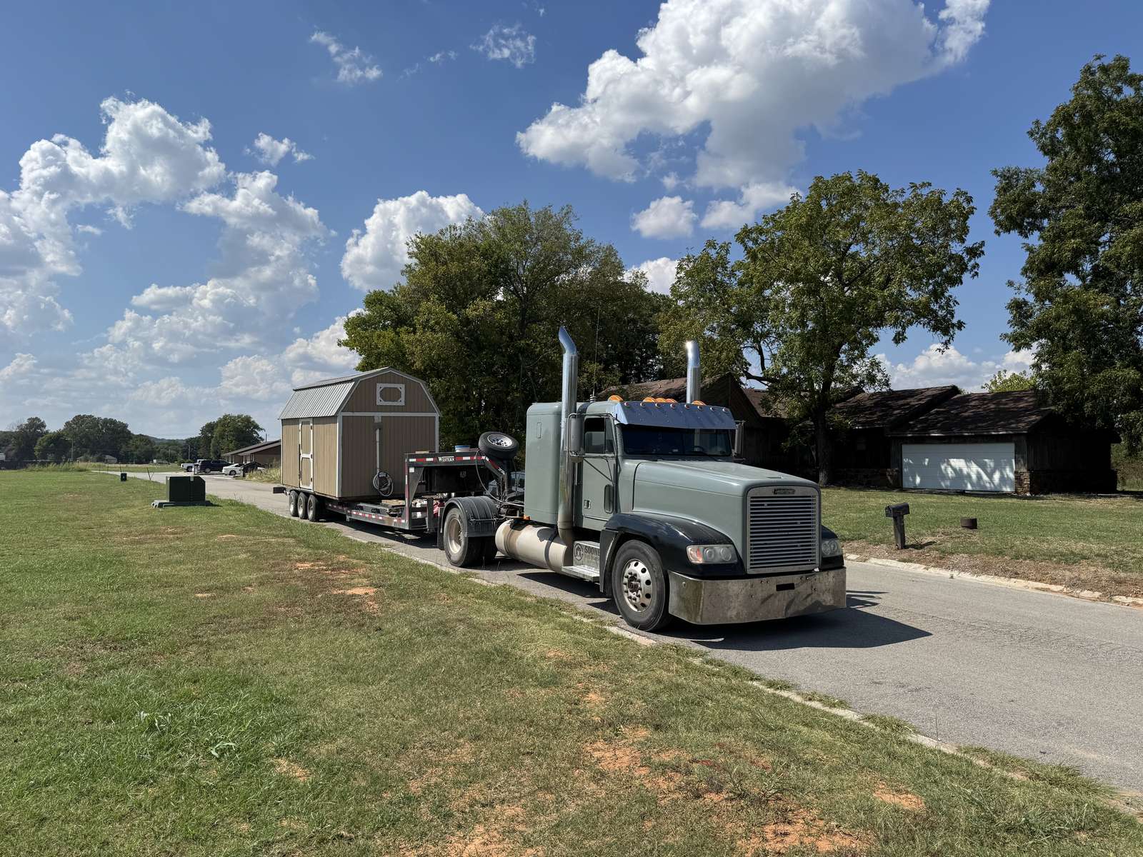 Tan lofted barn on the truck on a paved road