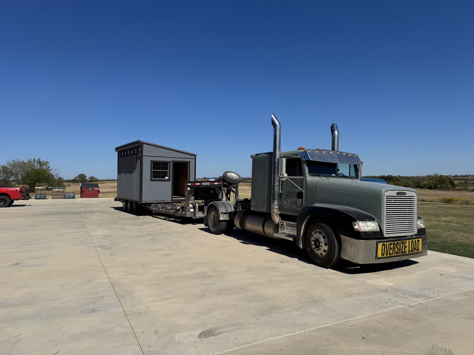 Gray shed loaded on the Sooner Shed Transport truck